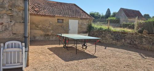 a ping pong table in a courtyard next to a building at L'Orée de Tronçais in Le Plaix
