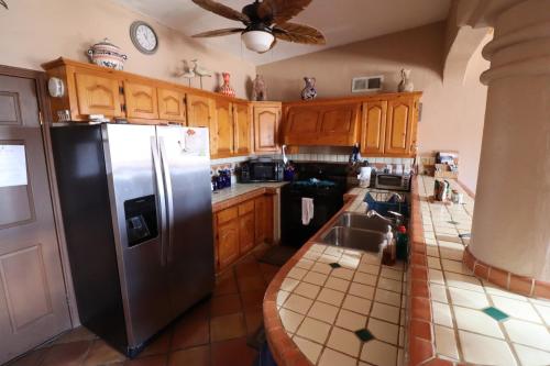 a kitchen with wooden cabinets and a stainless steel refrigerator at Campbell's house 2nd row WiFi Las Conchas in Las Conchas