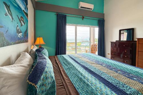 Un dormitorio con una cama con una lámpara y una ventana. en Suite C303 Mara Laguna, en San Pedro