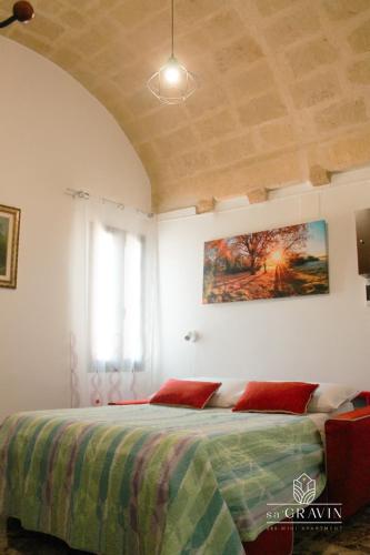 a bedroom with a bed with red pillows on it at B&B sa' GRAVIN in Castellaneta