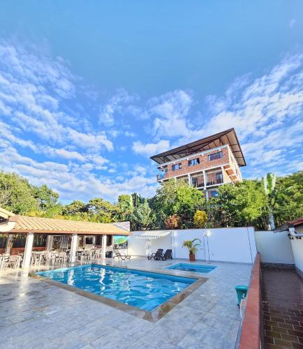 a swimming pool in front of a building at Hotel Finca Recreacional La Fortaleza 