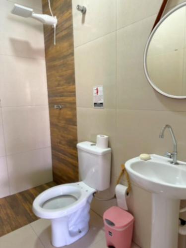 a bathroom with a toilet and a sink and a mirror at Refúgio Gourmet com Piscina Privativa in Nova Odessa