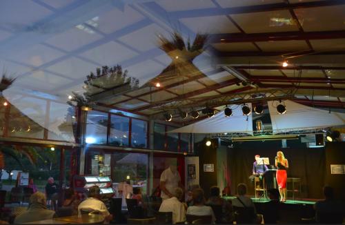 a woman on a stage in a room with people at Nouveau bungalow No 575 Camping 4 étoiles Lac des Rêves in Lattes