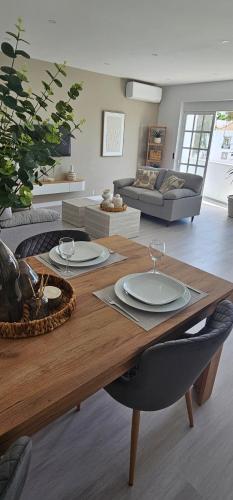 a living room with a wooden table with plates on it at River View Tavira - New Listing, Newly Renovated in Tavira