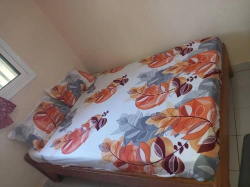 a couch with a flowered pillow on it at Fèmi in Rufisque