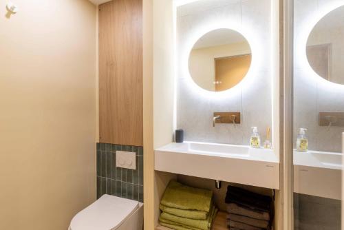 une salle de bain avec toilettes, lavabo et miroir dans l'établissement appartement aperçu vu mer avec garage, à Sainte-Maxime