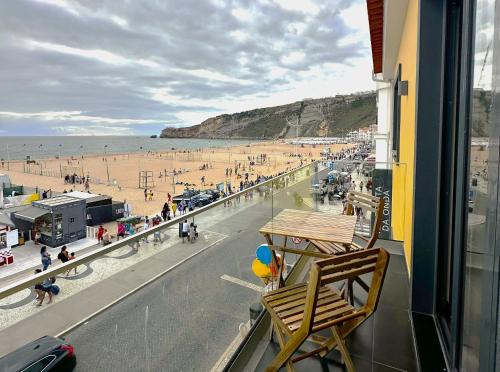 a balcony with a view of a beach with a chair at Na Crista da Onda in Nazaré