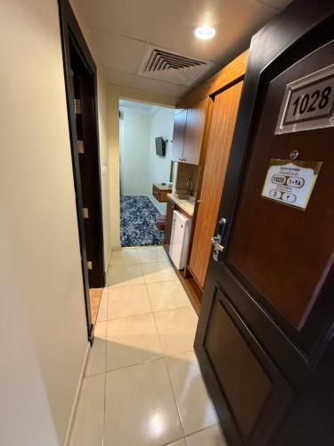 a door leading to a room with a kitchen and a hallway at فندق تارا الروضة in Makkah