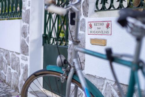 a bike parked next to a wall with a sign on it at Retiro das Buganvílias in Sesimbra