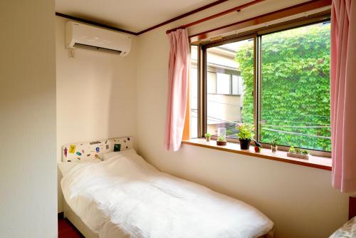 a small bedroom with a bed and a window at Shinjuku Y HOTEL II 1 minute to 7-Eleven 6DK 2 bathrooms in Tokyo