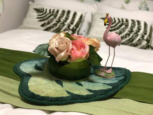 a vase with flowers and a flamingo statue on a bed at Shinjuku Y HOTEL II 1 minute to 7-Eleven 6DK 2 bathrooms in Tokyo