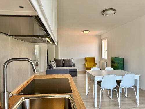 a kitchen and living room with a table and chairs at 1Dest - The Roman Spot in Riva del Garda