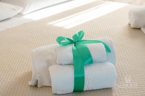 a stack of towels with a green bow on a bed at B&B sa' GRAVIN in Castellaneta