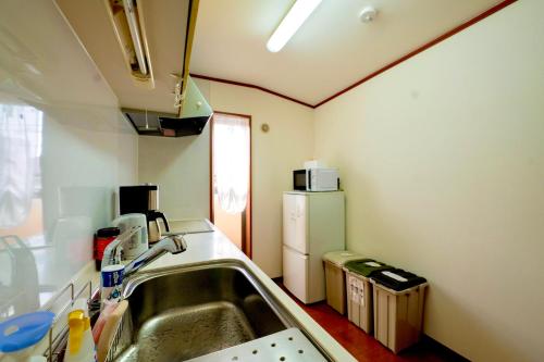 a kitchen with a sink and a refrigerator at Shinjuku Y HOTEL II 1 minute to 7-Eleven 6DK 2 bathrooms in Tokyo
