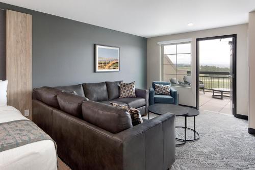 a living room with a couch and a bed at ClubHouse Hotel & Suites Rapid City in Rapid City