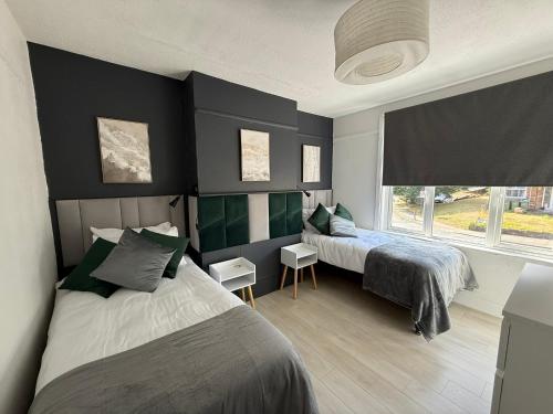 a bedroom with two beds and a window at Abbey Wood Residence in Abbey Wood