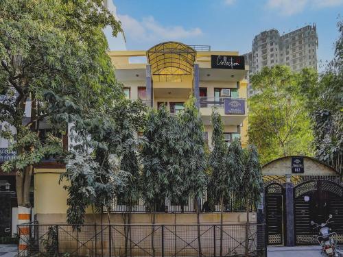 a building with a gate and trees in front of it at Hotel O Uk House Residency in Gurgaon