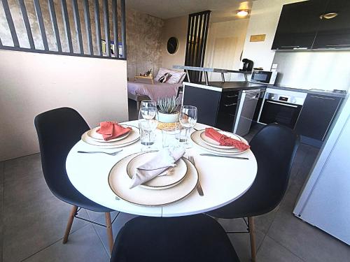 un tavolo bianco con piatti di cibo sopra in una cucina di LeRelaisdOdile - Idéal PRO & Couple - Studio Cosy - Proche Metro - Parking Gratuit - Mons-en-Barœul - - WIFI HD - Smart TV - Entrée Autonome a Mons-en-Baroeul