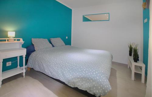 a bedroom with a bed and a blue wall at Awesome Home In Morières Les Avignon in Morières-lès-Avignon