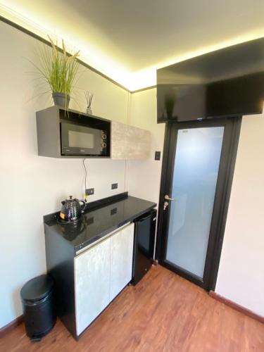a small kitchen with a black counter and a door at Cabañas Habitainer BordeRio 2 in Concepción