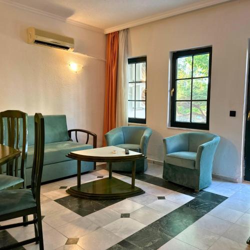 a living room with a couch and chairs and a table at Club Mel Holiday in Ortaca