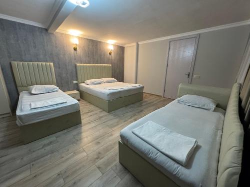 a room with two beds and a couch in it at Karo Hotel in K'obulet'i
