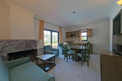 a kitchen and living room with a couch and a fireplace at Club Mel Holiday in Ortaca