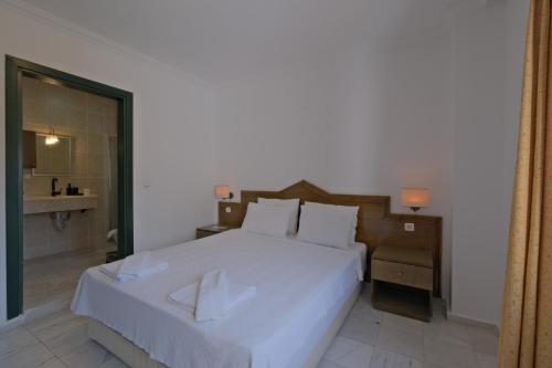 a bedroom with a large white bed and a bathroom at Club Mel Holiday in Ortaca