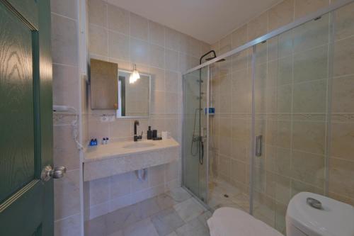 a bathroom with a shower and a sink and a toilet at Club Mel Holiday in Ortaca