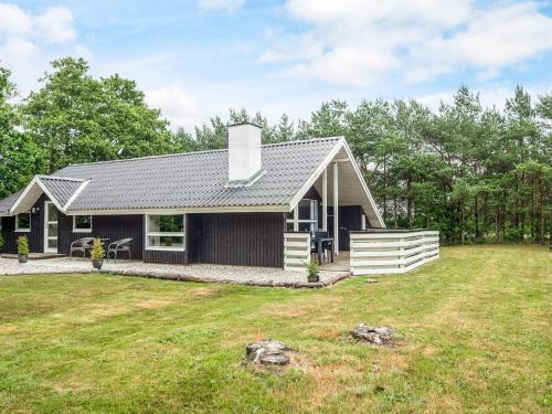 a small black house with a yard at Bright Cottage with Covered Terrace-By Traum in Nørre Nebel