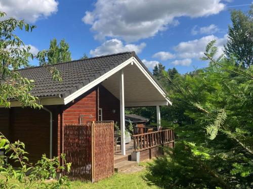 a small house with a porch and a fence at Nordic Charm with Spa - By Traum Ferienwohnungen in Kolind