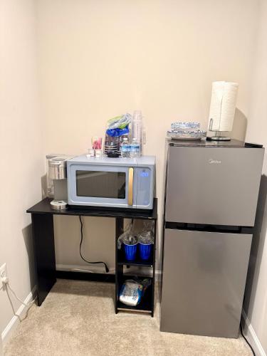 a microwave on a stand next to a refrigerator at Home Away in Hanover