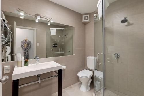 a bathroom with a sink and a toilet and a shower at Queenstown House Bed & Breakfast and Apartments in Queenstown