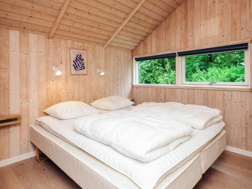Cama grande en habitación de madera con ventana en 7 person holiday home in Oksbøl, en Oksbøl