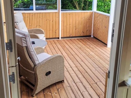 a porch with wicker chairs on a wooden deck at 7 person holiday home in Højslev-By Traum in Højslev