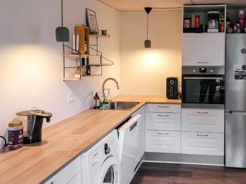 a kitchen with white cabinets and a stainless steel refrigerator at 7 person holiday home in Højslev-By Traum in Højslev