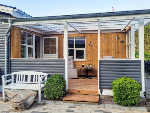 a pergola over a wooden deck with a white bench at 7 person holiday home in Højslev-By Traum in Højslev