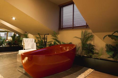 a large red tub in a bathroom with plants at Tare Houses in Istanbul