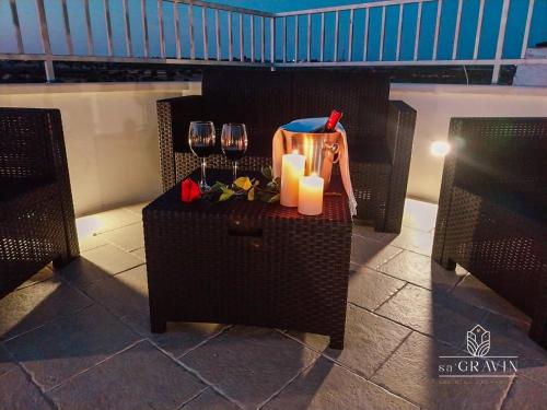 a table with two wine glasses and two candles at B&B sa' GRAVIN in Castellaneta
