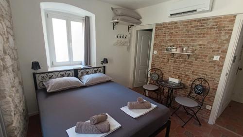 a bedroom with a bed and a brick wall at Roko's in Hvar
