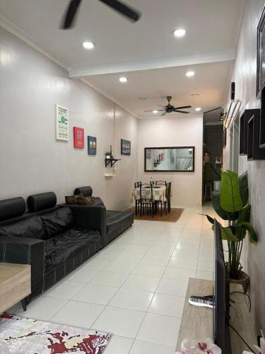 a living room with a couch and a dining room at Homestay Sakinah No 39 in Tanjung Malim