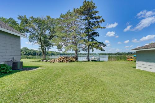 a yard with two trees and a house at Lakefront Mound Getaway Near Snowmobiling Trails! in Mound