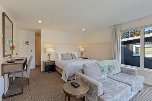 a hotel room with a bed and a couch at Queenstown House Bed & Breakfast and Apartments in Queenstown