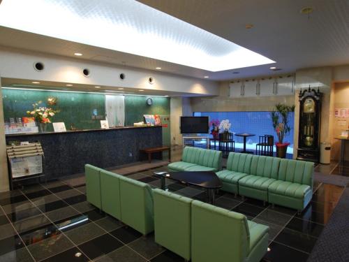 福岡市にあるMinami Fukuoka Green Hotel - Vacation STAY 34039vの緑のソファとバーが備わる待合室
