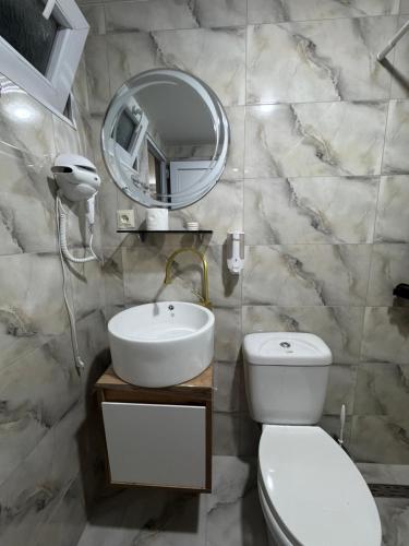 a bathroom with a toilet and a sink and a mirror at Karo Hotel in K'obulet'i