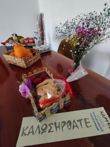 a table with a basket of fruit and a vase of flowers at TriΖin in Galatas