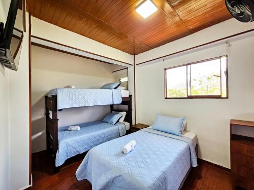 a bedroom with two beds and a window at Hotel Finca Recreacional La Fortaleza 