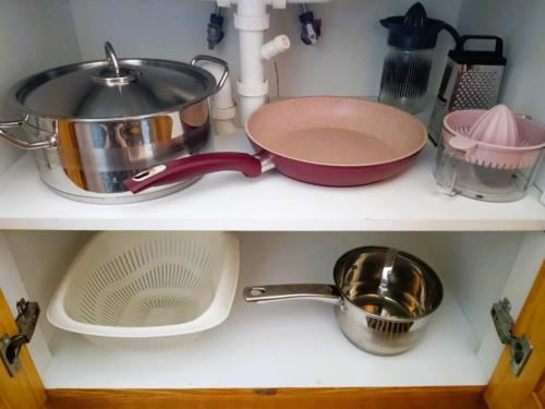 a shelf with pots and pans and other kitchen items at TriΖin in Galatas