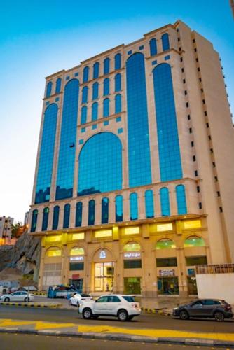 a large building with cars parked in front of it at فندق تارا الروضة in Makkah