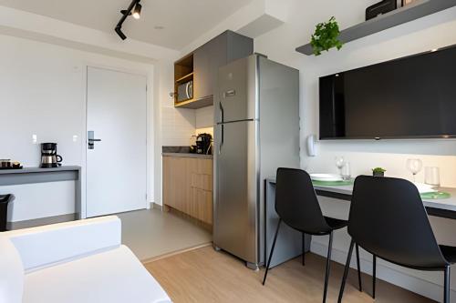 a kitchen with a table and chairs and a refrigerator at Today Perdizes in Sao Paulo